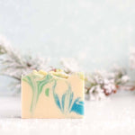 Bar of soap with green and blue marbled pattern on a light background