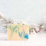 Bar of soap with green and blue marbled pattern on a light background